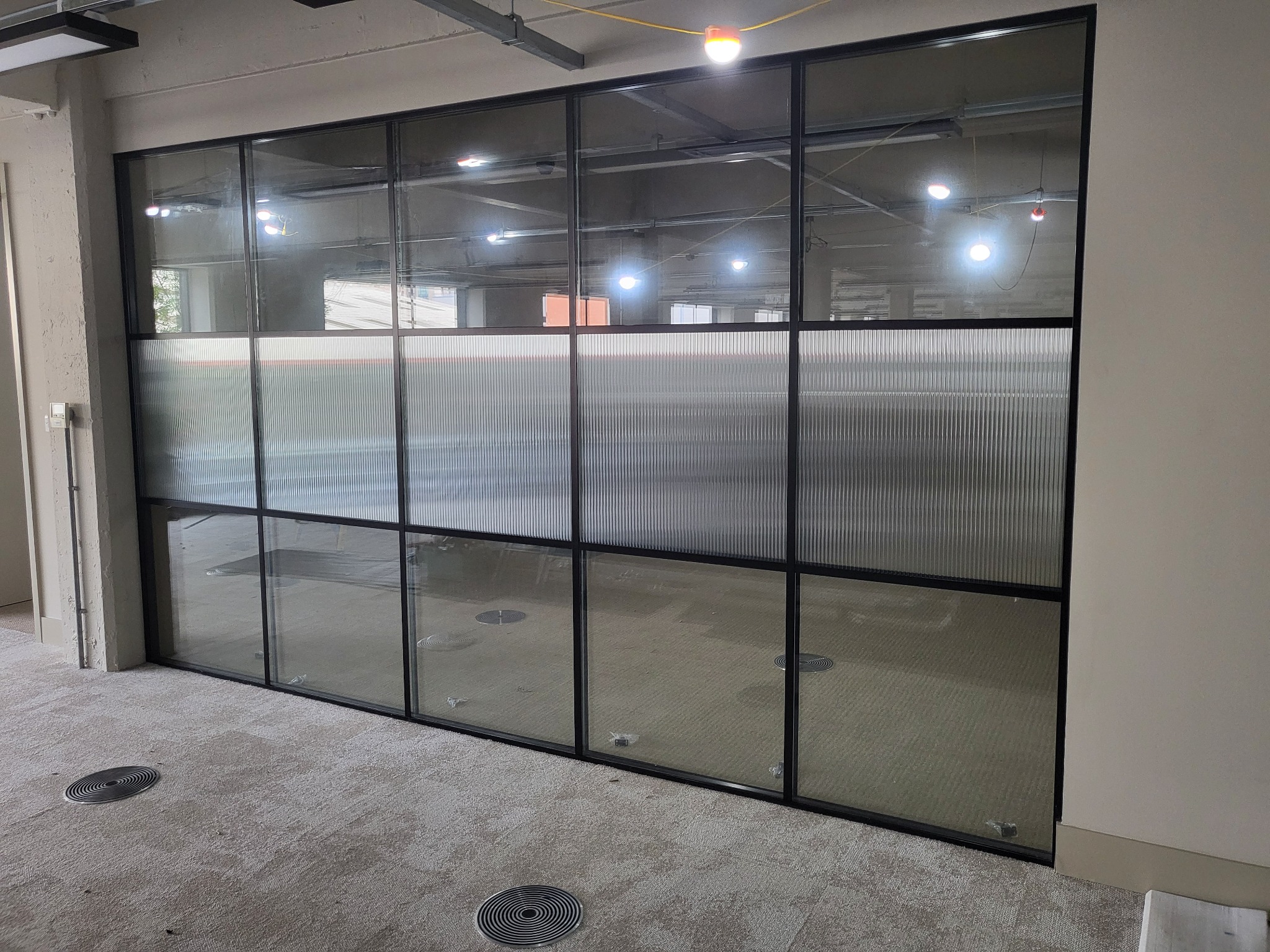 Reeded privacy window film installed across the middle of office partition glazing